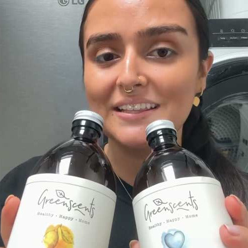 Person holding two bottles of greenscents