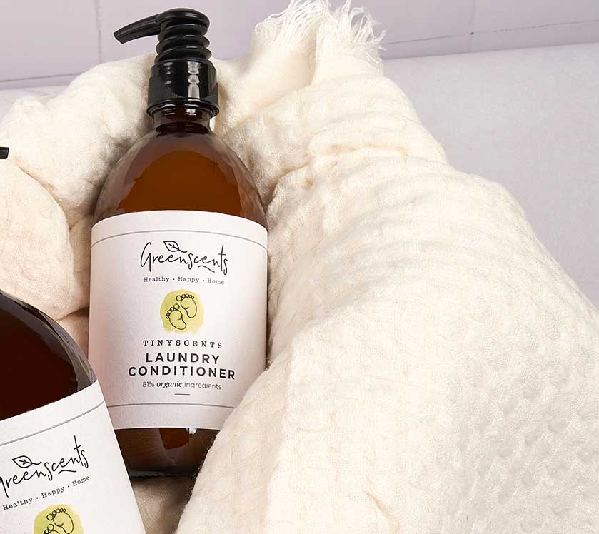 Bottle of TinyScents laundry conditioner on a textured surface