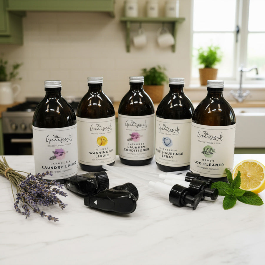 Set of Greenscents natural product bottles on a kitchen counter with ingredients like lavender and lemon.