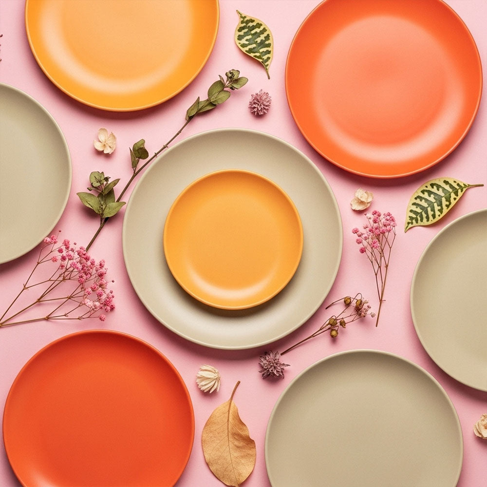 Colorful plates on a pink background with flowers and leaves.