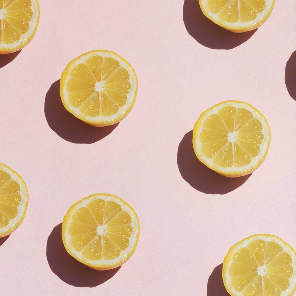 Sliced lemons on a pink background