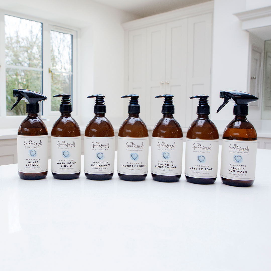 Set of greenscents cleaning product bottles with labels on a white surface